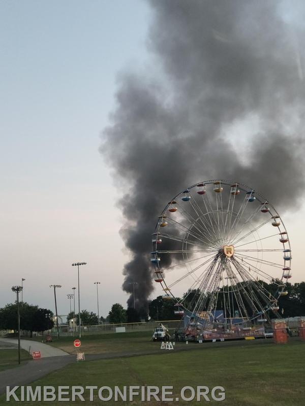 Firefighters coming into the fire station knew they were going to see action. Smoke billows over the Ferris wheel on the fairgrounds. 